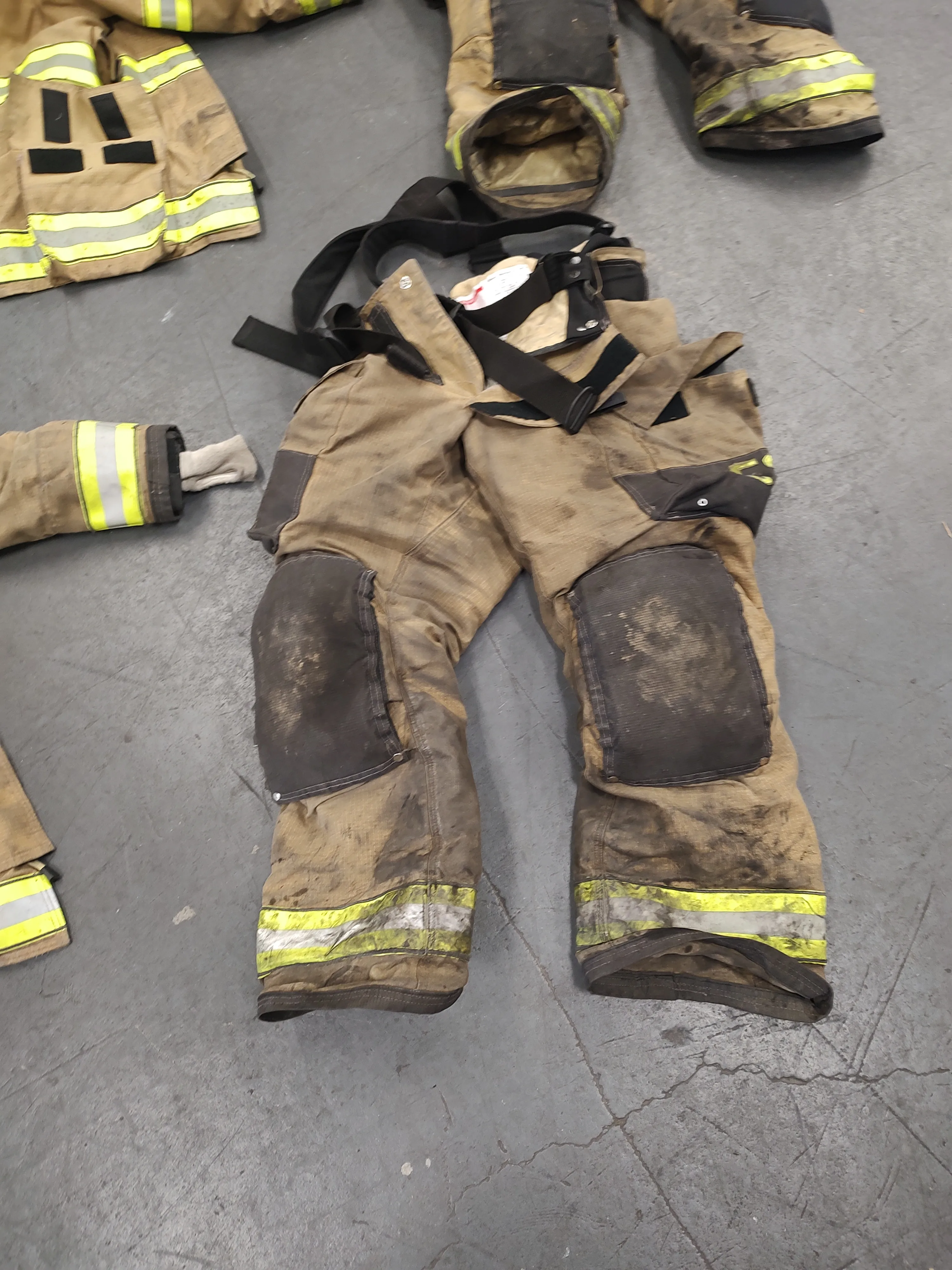 Dirty turnout gear laid out on the floor