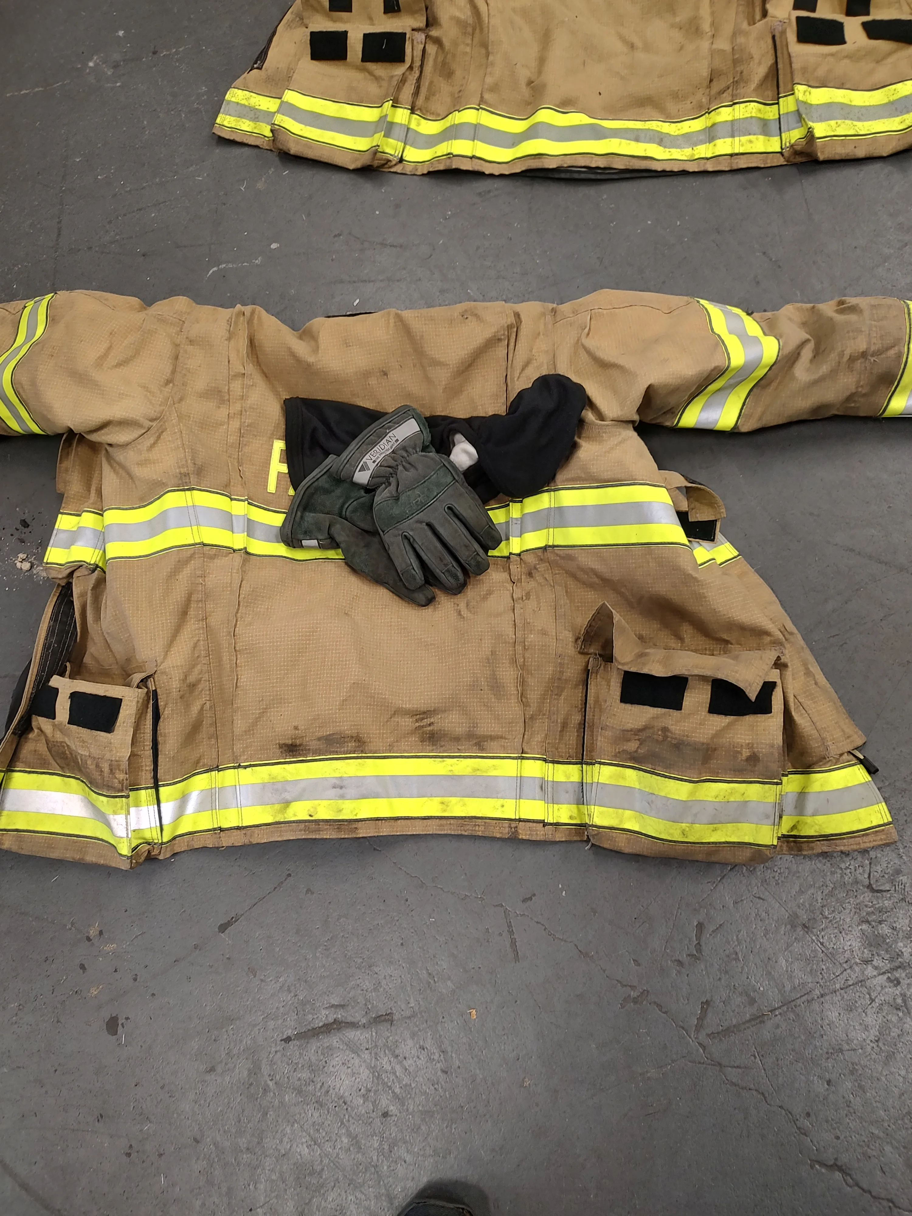 Turnout coat laid out with gloves for post-service review